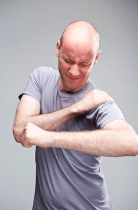 Person with shoulder impingement holding shoulder in pain