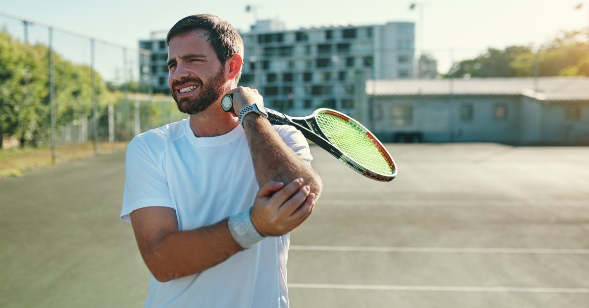 Tennis Player Grabbing Their Elbow In Pain | What is Tennis Elbow? | REACH Rehab + Chiropractic
