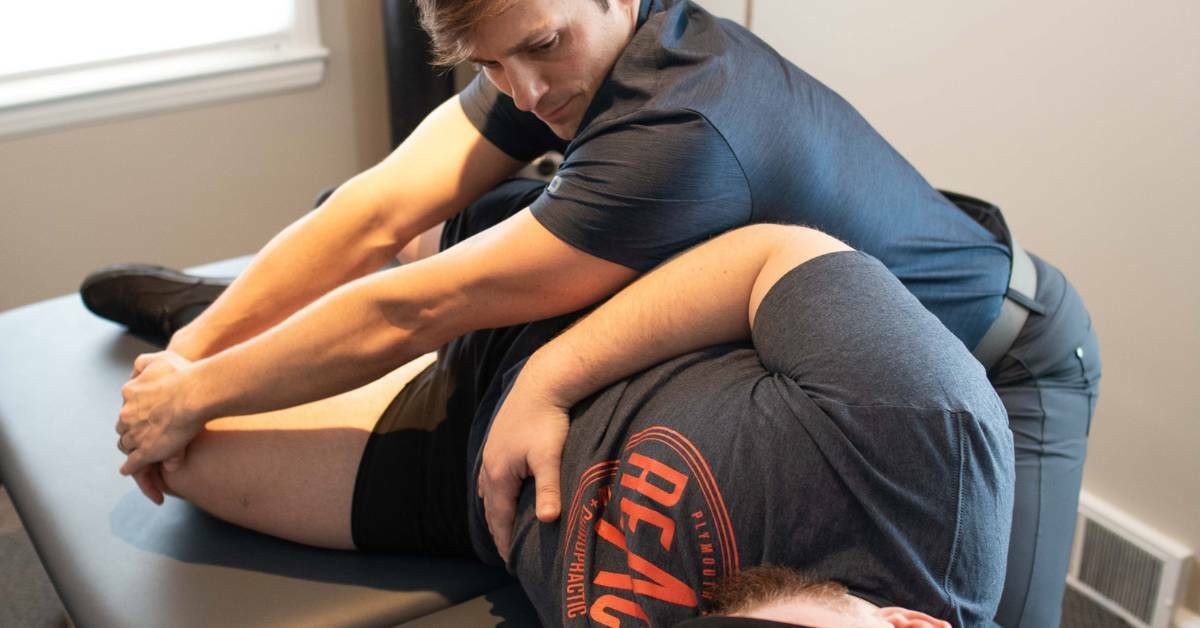A Chiropractor Helping a Patient Laying on A Table With Knee and Hip Pain | DIY Injuries | REACH Rehab + Chiropractic
