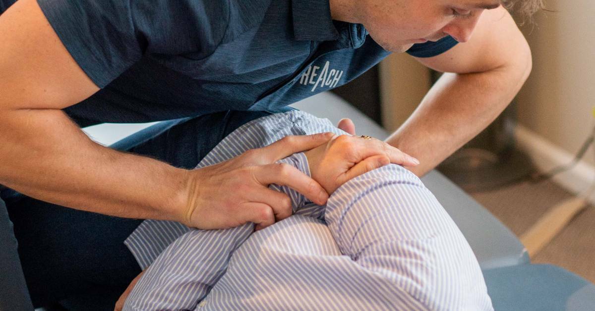 Chiropractor Helping a Patient With Hip and Back Pain | Holistic Chiropractic Care | REACH Rehab + Chiropractic