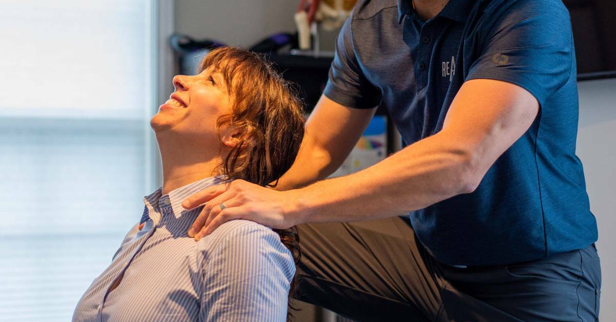 Woman getting their neck massaged by REACH practitioner. Chiropractic care and improved sleep.